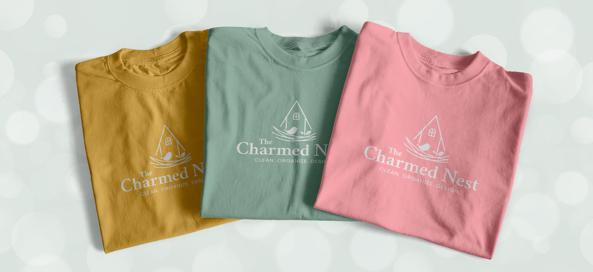 Mockup showing the logo in white on three different colored t-shirts.