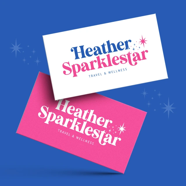 Two business cards are displayed diagonally against a blue background. One card is white with blue and pink text, and the other is pink with white text. Both feature the name "Heather Sparklestar" and "Travel & Wellness" along with star graphics.