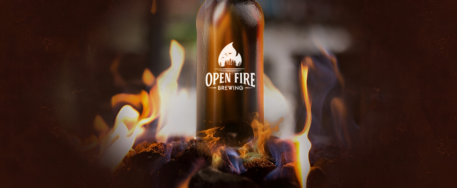 Open Fire Brewing logo on a beer bottle in front of flames.